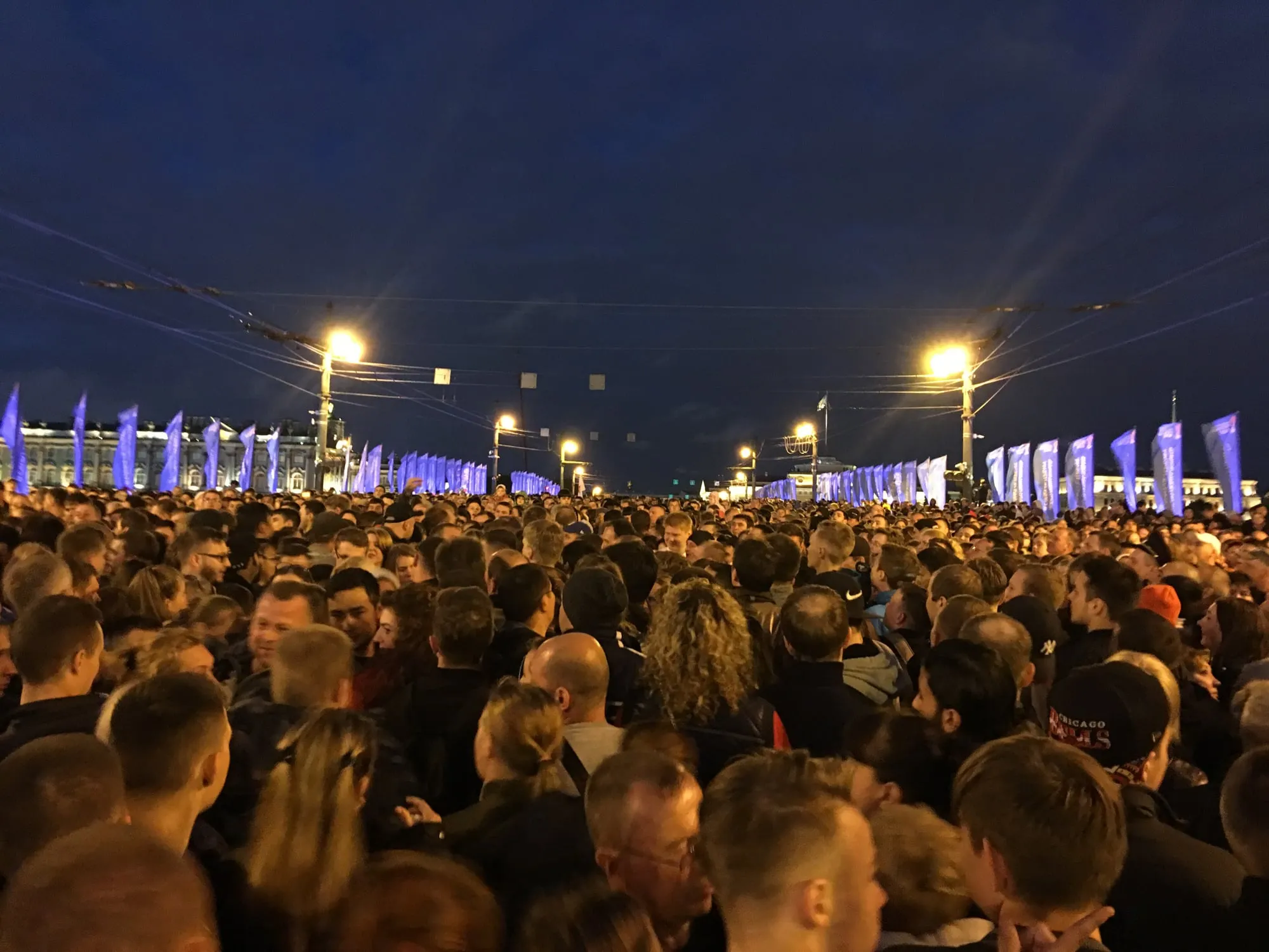 Толпа зрителей идёт по мосту после окончания Алых парусов ночью