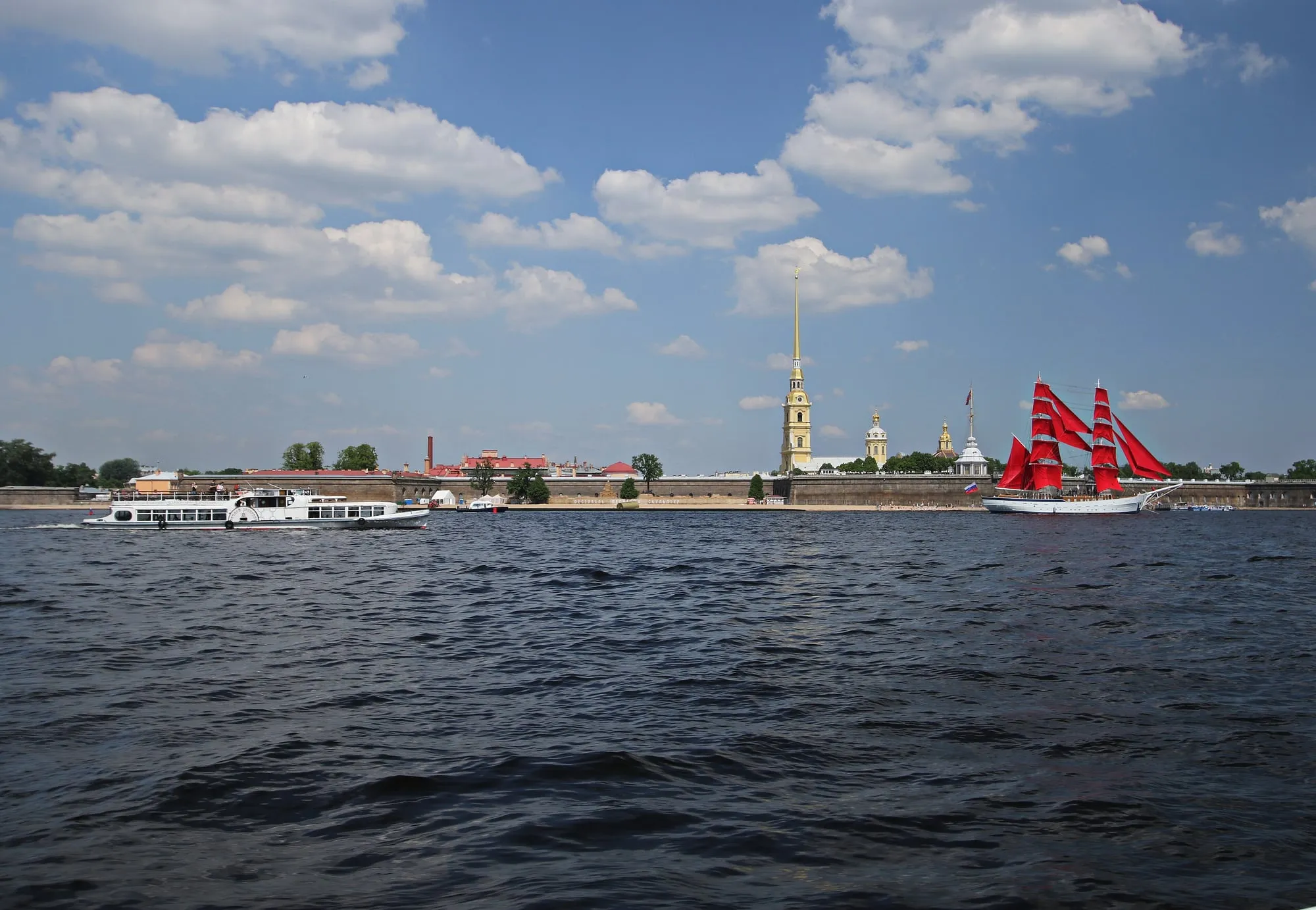 Прогулочный теплоход и парусник с алыми парусами на Неве у Петропавловской крепости